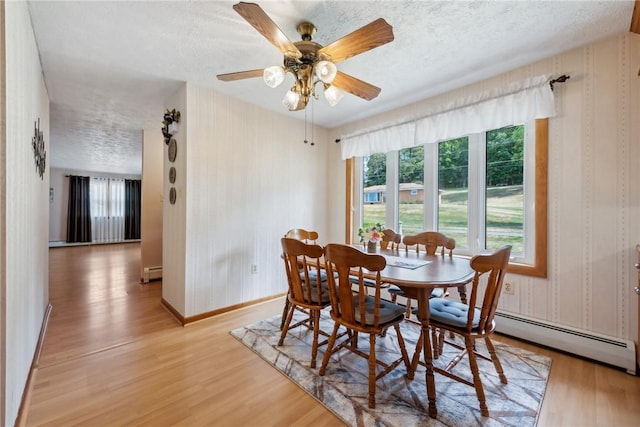 dining area with a textured ceiling, light wood-type flooring, plenty of natural light, and ceiling fan