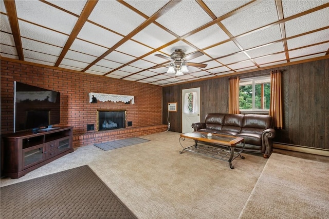 living room featuring ceiling fan, wood walls, light colored carpet, and a brick fireplace