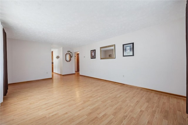 unfurnished room featuring a textured ceiling and light wood-type flooring