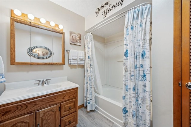 bathroom featuring hardwood / wood-style floors, vanity, and shower / bathtub combination with curtain