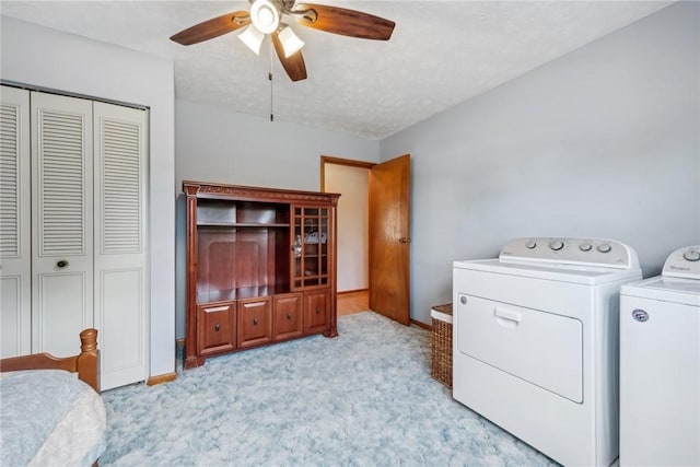 laundry room featuring a textured ceiling, ceiling fan, separate washer and dryer, and light carpet