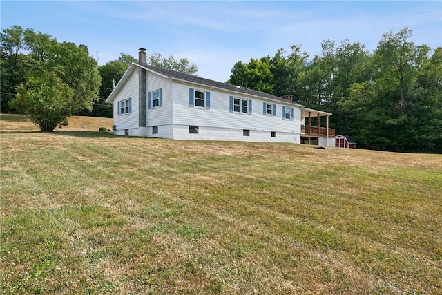 view of front of home featuring a front yard and a storage shed