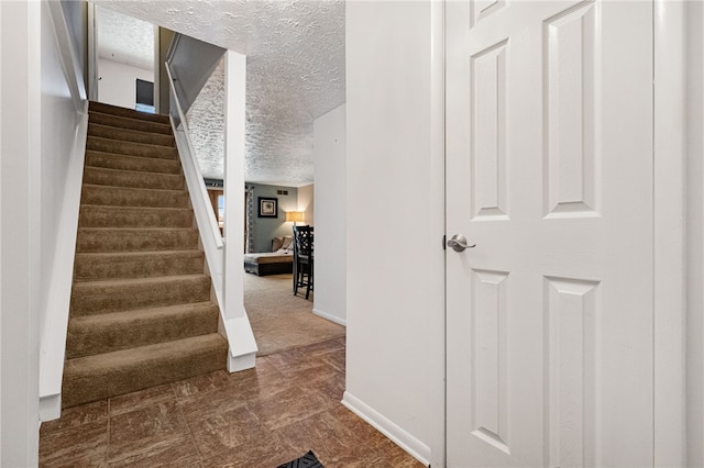 staircase with a textured ceiling