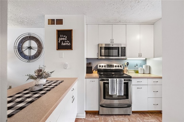 kitchen featuring white cabinets, a textured ceiling, and appliances with stainless steel finishes