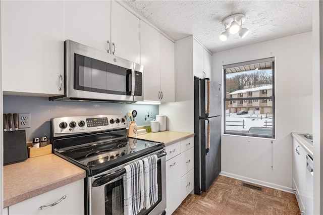 kitchen with white cabinets, stainless steel appliances, and a textured ceiling