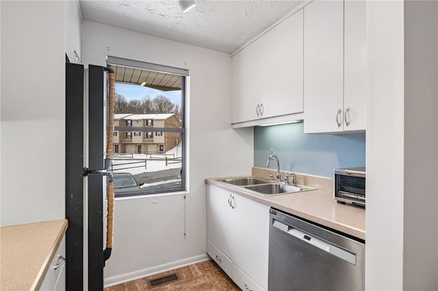 kitchen featuring sink, white cabinets, stainless steel appliances, and a textured ceiling