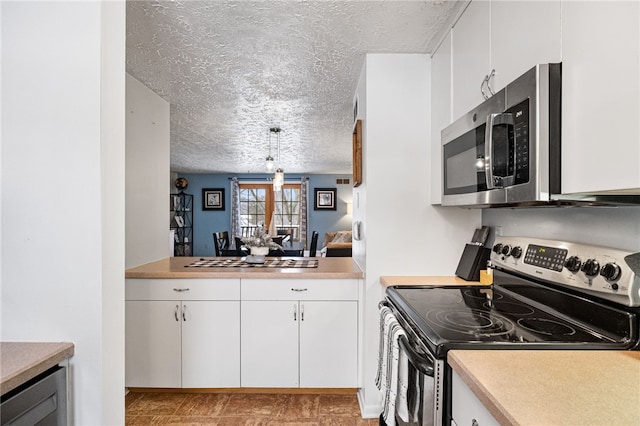 kitchen with a textured ceiling, stainless steel appliances, beverage cooler, white cabinetry, and hanging light fixtures