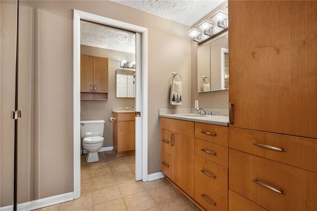 bathroom with vanity, a textured ceiling, toilet, and tile patterned flooring