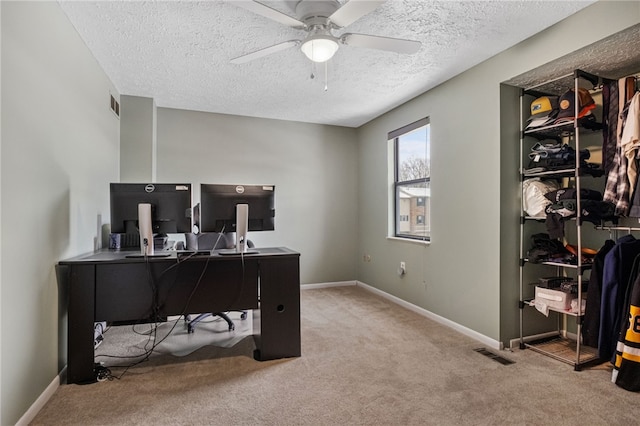 carpeted office featuring ceiling fan and a textured ceiling