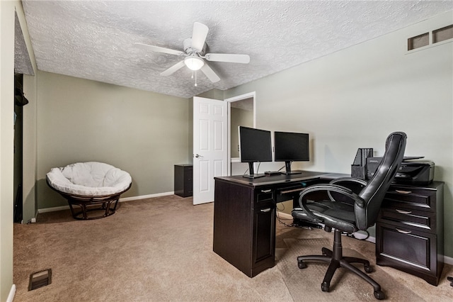 office space featuring light carpet, ceiling fan, and a textured ceiling