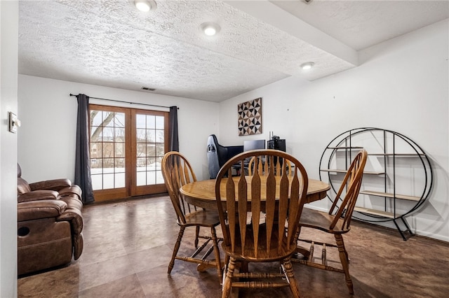 dining room with french doors and a textured ceiling