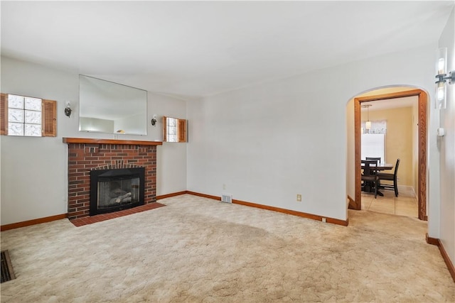 unfurnished living room featuring a fireplace and light colored carpet