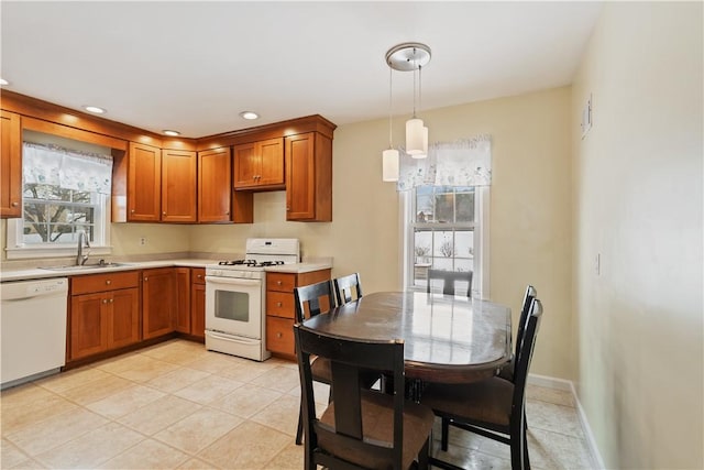 kitchen featuring pendant lighting, white appliances, a healthy amount of sunlight, and sink