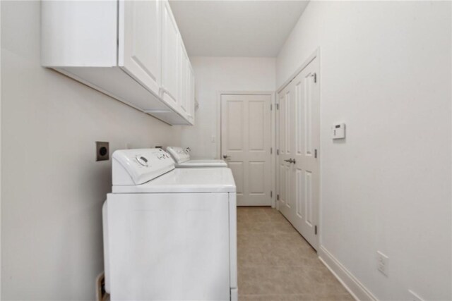 washroom featuring washer and dryer and cabinets