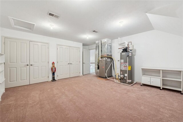 basement featuring gas water heater, carpet floors, and heating unit