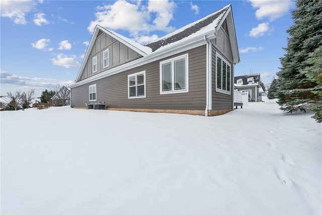 view of snow covered exterior featuring central AC unit