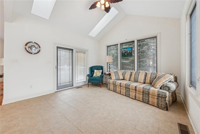 living room featuring a healthy amount of sunlight, ceiling fan, and a skylight