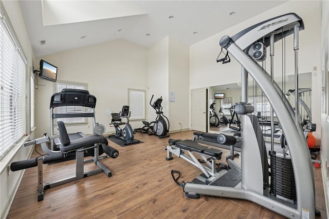 gym with hardwood / wood-style flooring and high vaulted ceiling