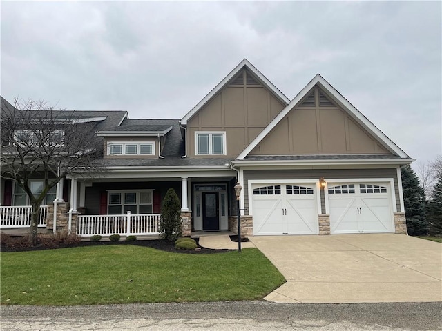 craftsman inspired home featuring a garage, a front yard, and a porch