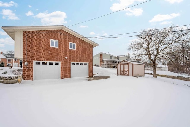 snow covered property with a storage shed