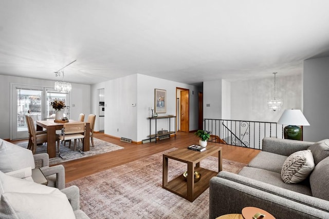 living room featuring a notable chandelier and light hardwood / wood-style floors