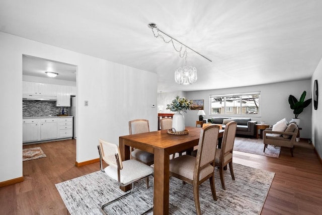 dining area with a notable chandelier and dark hardwood / wood-style floors