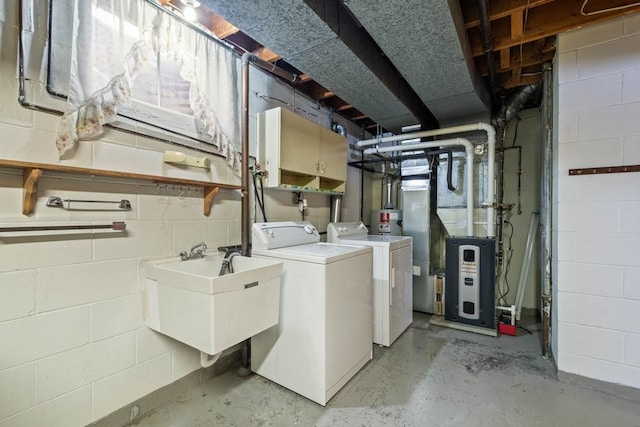 clothes washing area with washing machine and dryer, sink, cabinets, and heating unit