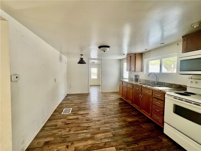 kitchen featuring white electric range, hanging light fixtures, dark wood-type flooring, and sink