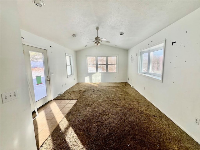 unfurnished living room with a textured ceiling, ceiling fan, light carpet, and vaulted ceiling