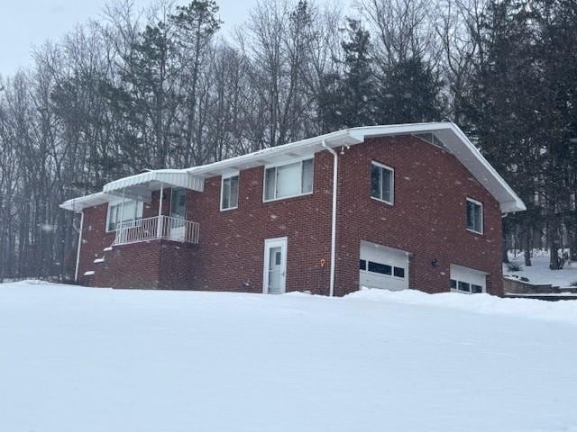 snow covered property with a garage