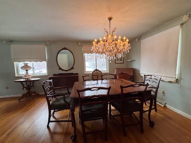 dining area with wood-type flooring and a chandelier