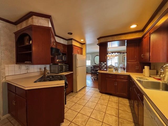 kitchen featuring dishwasher, white fridge, sink, and crown molding