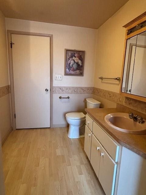 bathroom with vanity, hardwood / wood-style floors, tile walls, and toilet