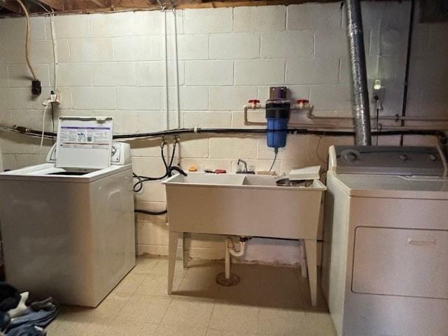 clothes washing area with independent washer and dryer and sink