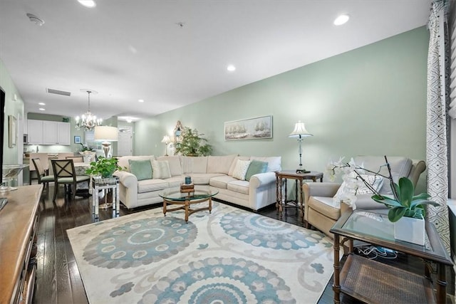 living room with an inviting chandelier and dark wood-type flooring