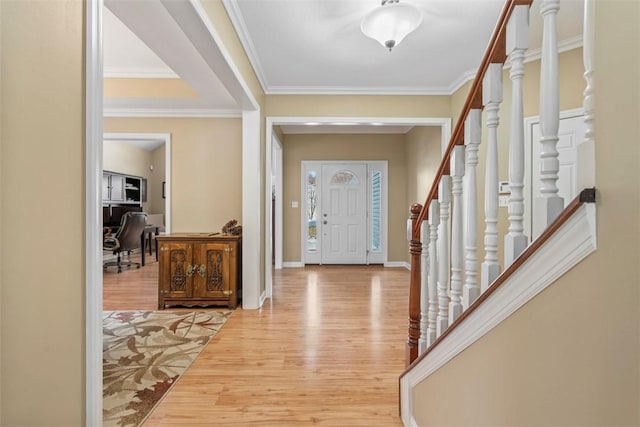 foyer entrance with light hardwood / wood-style floors and crown molding