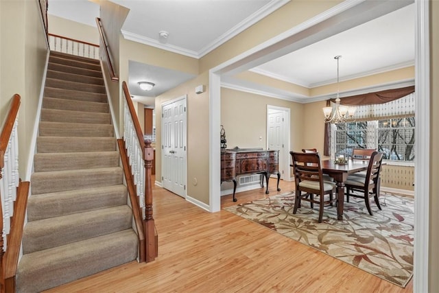 dining space with hardwood / wood-style floors, crown molding, and a notable chandelier