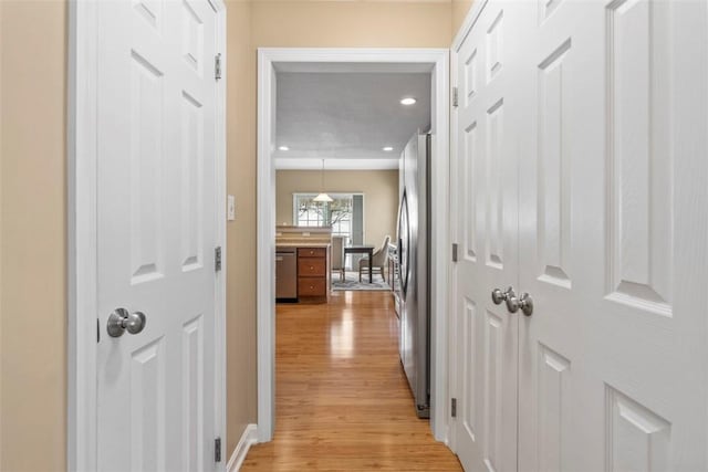 hallway with light hardwood / wood-style floors