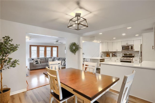 dining room featuring ceiling fan, light hardwood / wood-style flooring, and sink