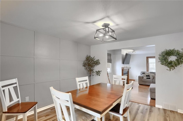 dining room with light hardwood / wood-style floors and tile walls