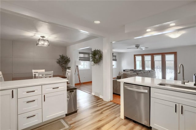 kitchen with ceiling fan, sink, stainless steel dishwasher, white cabinets, and light wood-type flooring