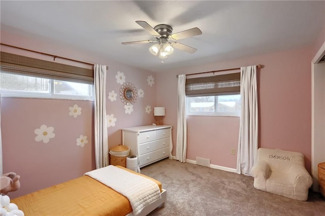 carpeted bedroom featuring ceiling fan and multiple windows