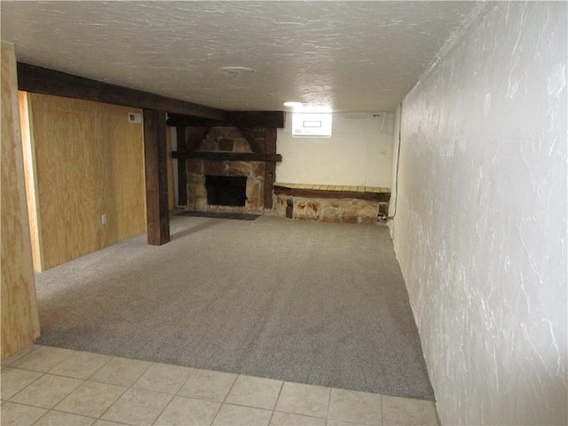 basement featuring light carpet and a fireplace