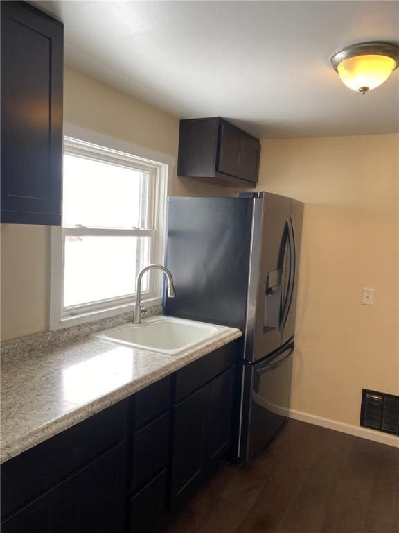 kitchen featuring stainless steel refrigerator with ice dispenser, dark hardwood / wood-style floors, and sink