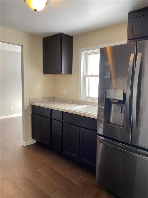 kitchen featuring hardwood / wood-style flooring, stainless steel fridge, and sink