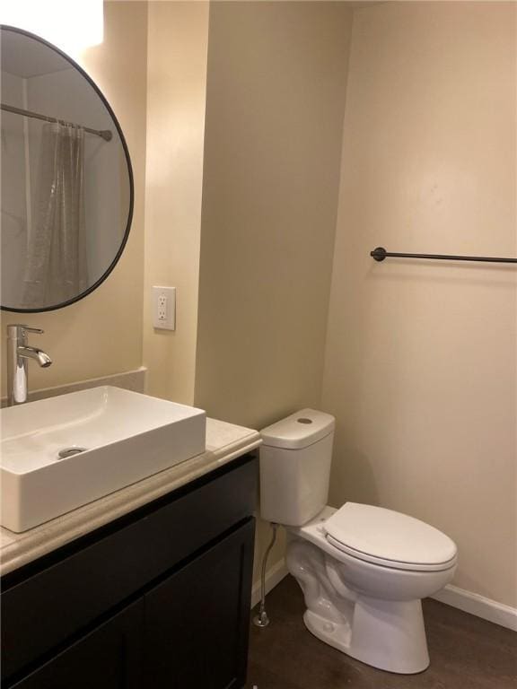 bathroom featuring toilet, vanity, and a shower with shower curtain