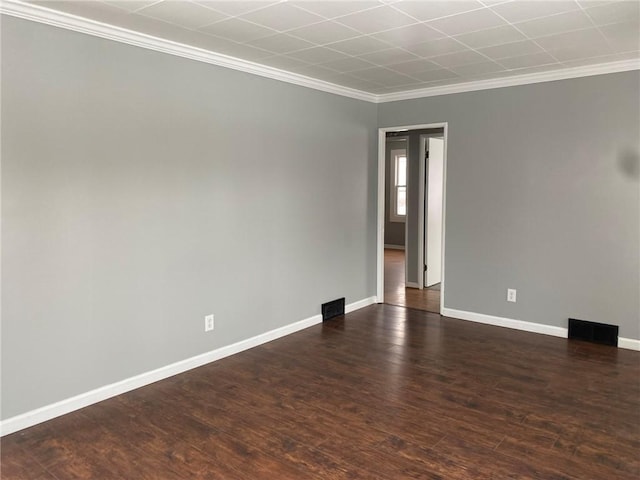 empty room with dark hardwood / wood-style flooring and ornamental molding