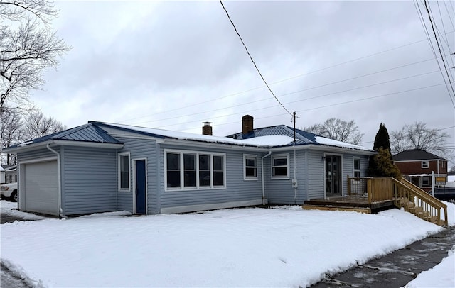 snow covered property featuring a garage