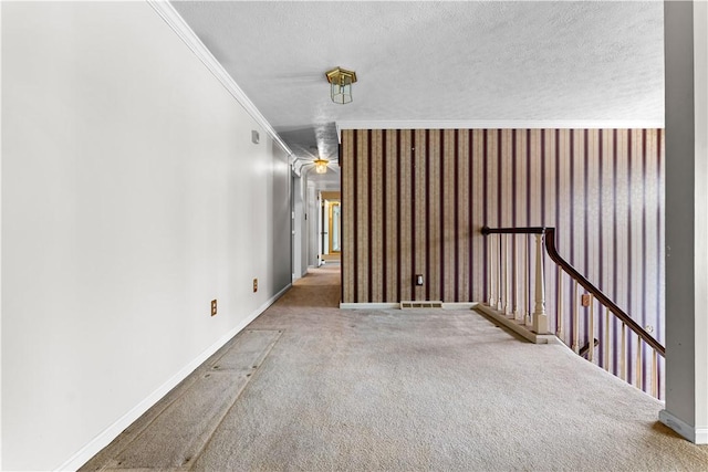 hallway featuring carpet floors, a textured ceiling, and ornamental molding