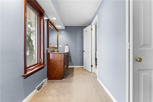 hallway featuring light colored carpet